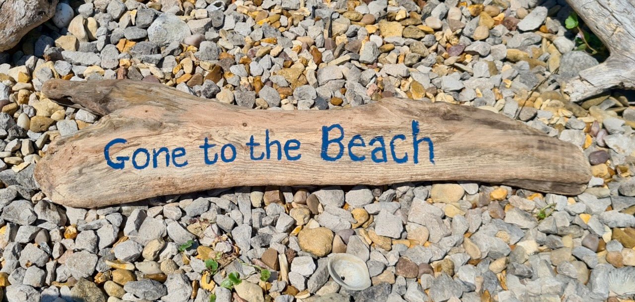 driftwood log with "gone to the beach" painted on