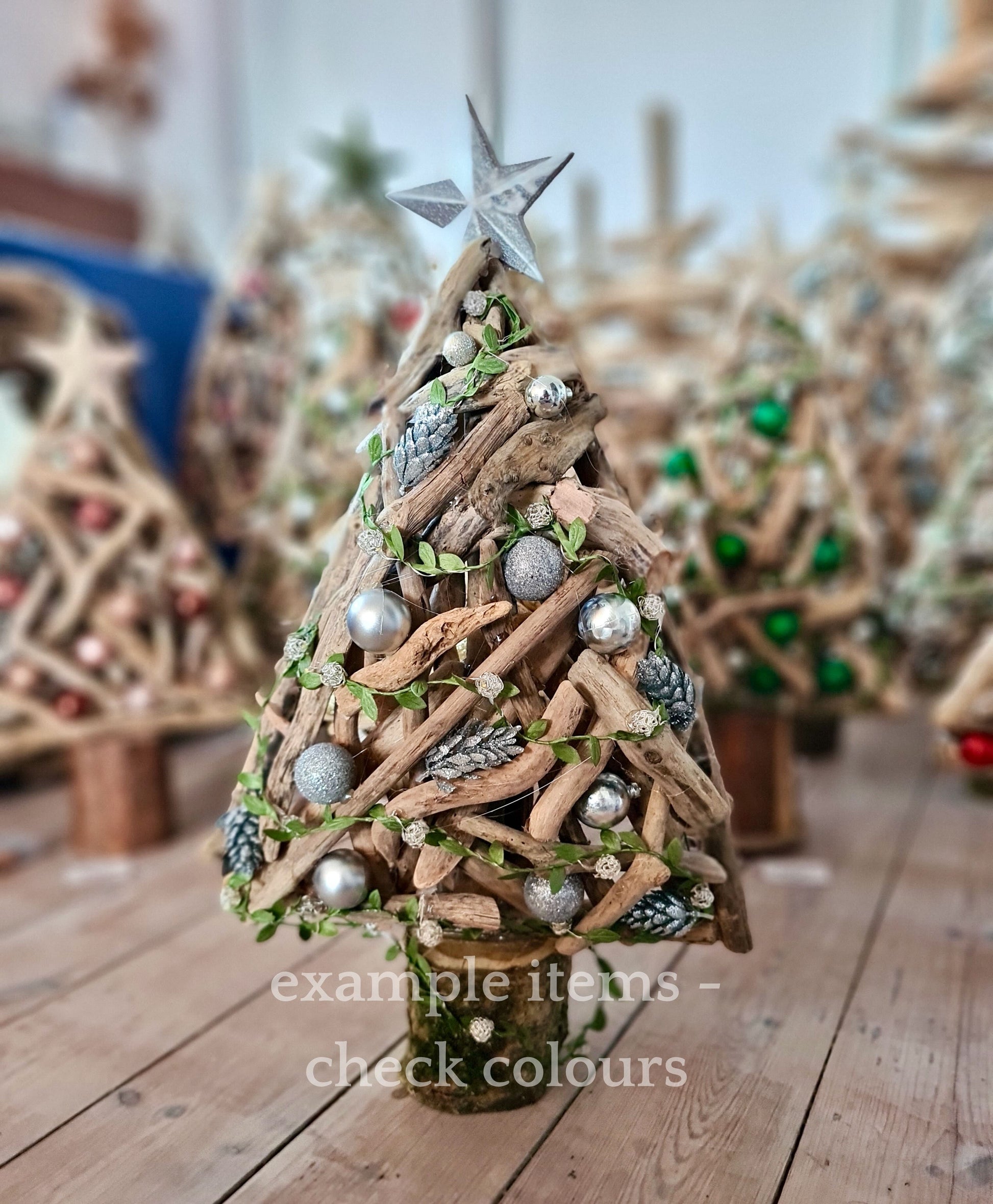 Decorative Christmas tree made of driftwood with ornaments on a wooden surface.