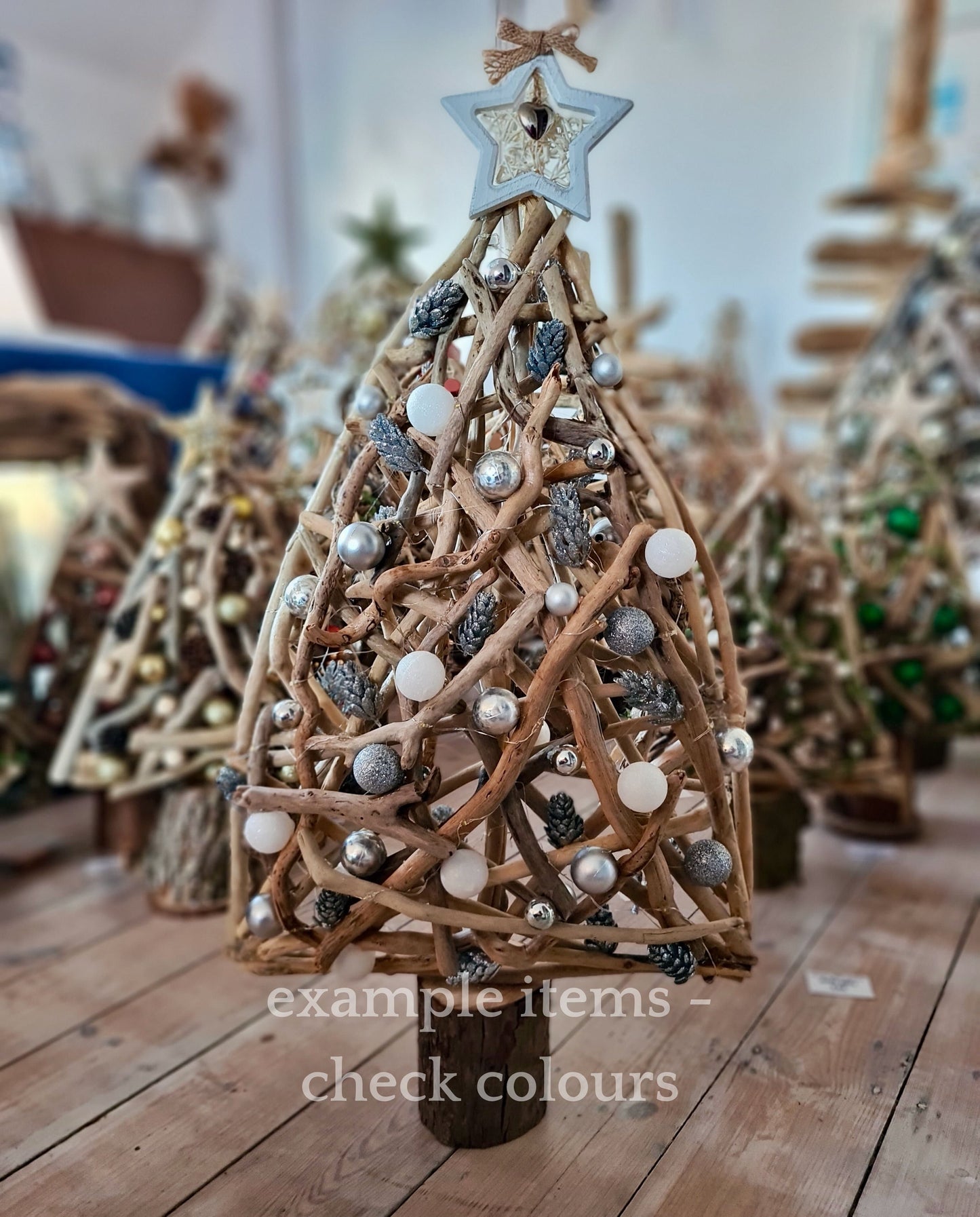 Decorative Christmas tree made of driftwood with ornaments on a wooden floor.