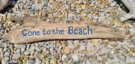 driftwood log with "gone to the beach" painted on